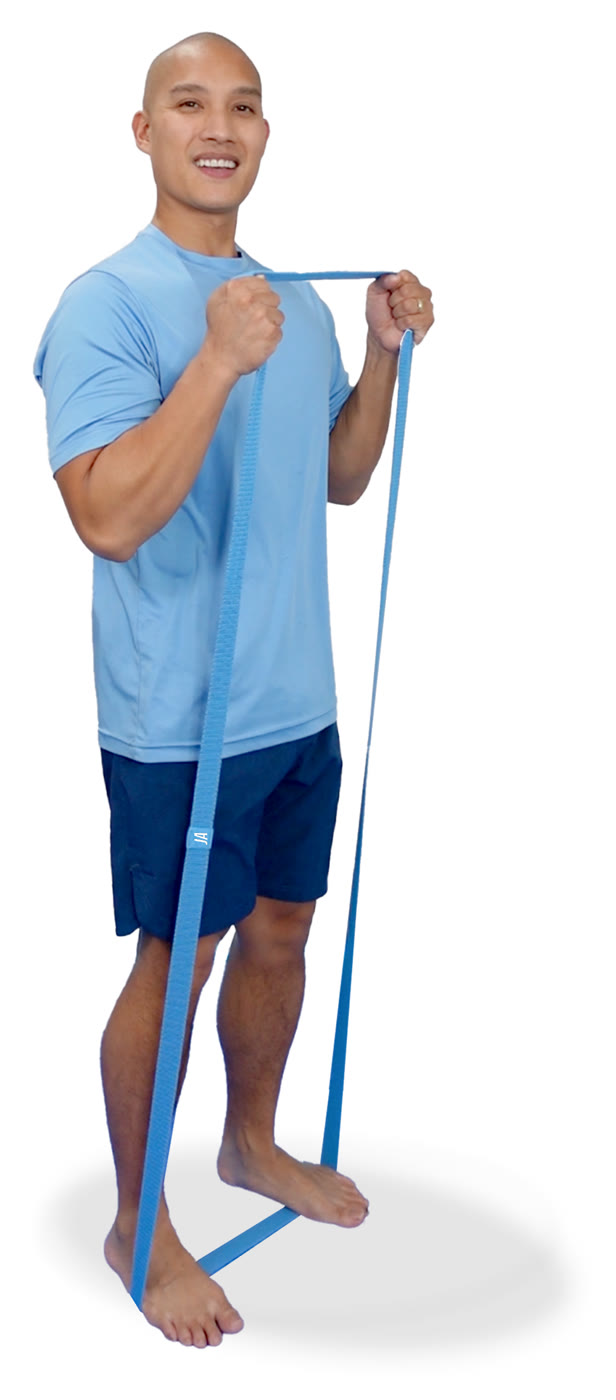 Justin Agustin standing and exercising with a blue fabric band looped under his foot
